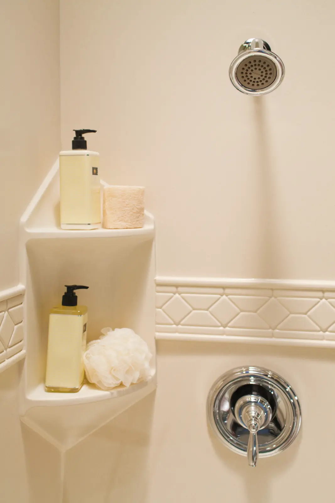 Biscuit two-shelf corner caddy in beige granite smooth wall with listello trim